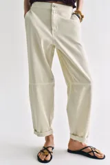 Pantalón de tiro bajo estilo chino, color blanco, con bolsillos delanteros, bolsillos de plastrón en la espalda y bajo acabado con vuelta. Cierre frontal con cremallera y botón.