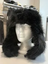 Gorro estilo ruso de piel sintética negra, con diseño de solapas laterales y cierre mediante clip ajustable.