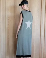 Vestido largo sin mangas color verde militar, con cuello redondo y ribete negro. Presenta una gran estrella blanca estampada en la espalda y un ribete negro en el dobladillo.