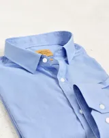 Camisa de vestir de manga larga en color azul con micro rayas blancas, confeccionada en algodón easy iron. Presenta cuello clásico, cierre frontal con botones y puños con botones.