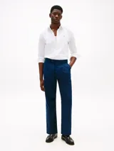 Camisa blanca de corte regular confeccionada en tejido dobby de puro algodón, con cuello inglés, puños redondeados con botón y logo de Tommy Hilfiger bordado en el pecho.