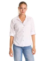 Camisa blanca de algodón con cuello solapa, escote en V y cierre frontal con botones decorativos de strass. Presenta pinzas de entalle para un ajuste definido, mangas tres cuartos con terminación rebatible y ruedo redondeado.