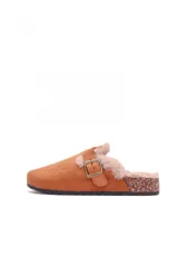 Sueco tipo zueco de gamuza color beige, con interior forrado en piel sintética suave y detalle de tira con hebilla metálica ajustable en el empeine. Suela de corcho y base de goma antideslizante.