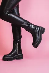 Botas negras de cuero con caña media, cierre lateral con cremallera y suela de plataforma track.