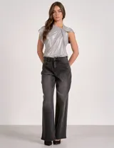 Blusa sin mangas color gris con tejido lurex brillante y detalle de nudo drapeado en el cuello.