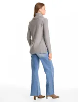 Buzo de punto color bordó con cuello volcado amplio y mangas largas. Presenta una costura central vertical en el frente y diseño con tajos laterales en el ruedo, siendo ligeramente más largo en la parte posterior.