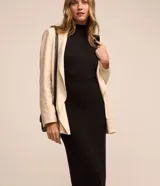 Vestido midi de Marfinno, confeccionado en tejido de punto acanalado (rib) con cuello alto y diseño sin mangas. Presenta un corte ajustado al cuerpo y un pequeño tajo en la parte trasera del ruedo.