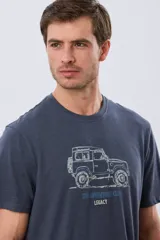 Remera Legacy de manga corta y cuello redondo, color azul melange, con estampa frontal y detalles bordados de un vehículo todoterreno acompañados por el texto "The Adventure Club".