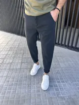 Pantalón jeans de corte slouchy, color negro gastado, suelto en la parte superior y ligeramente ajustado hacia los tobillos.