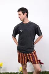 Remera gris de algodón con efecto acid wash, cuello redondo y mangas cortas. Presenta un pequeño logo estampado en el pecho y un estampado más grande en la espalda.