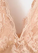 Top de encaje color nude con cuello en V, sin mangas, tirantes anchos y diseño recto.
