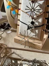 Collar con dije de alpaca y bronce hecho a mano con diseño de estrella solar, suspendido de un tiento de gamuza ajustable.