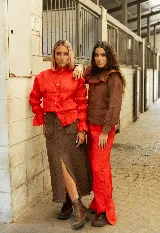 Pollera midi de jean color chocolate, con diseño de textura grabada, bolsillos frontales y tajo central delantero con ruedo desflecado.