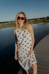 Vestido midi blanco con lunares negros, sin mangas y corte holgado.