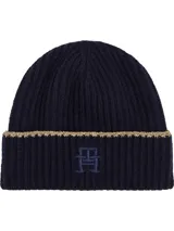 Gorro de lana azul marino con punto canalé y vuelta. Presenta un ribete dorado en el borde inferior y el monograma TH bordado en el frente.