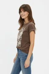 Remera azul marino de manga corta holgada con cuello redondo y estampa frontal de paisaje marino con fases lunares y flores.