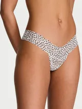 Tanga de encaje color blanco con estampado de lunares negros y bordes festoneados, de tiro bajo.