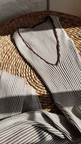 Vestido midi de punto acanalado, color beige con rayas verticales marrones, escote en V y abertura lateral.