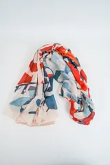 Pañuelo fino de tela ligera con estampado abstracto en tonos rojo, azul y beige.