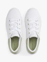 Zapatillas de tenis Tommy Hilfiger de corte bajo, confeccionadas en piel napa blanca con paneles de textura en color verde claro en el talón. Presentan suela gruesa de goma, cierre con cordones y logo metálico en bajo relieve en el lateral.