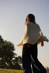 Poncho tejido en lana merino color marrón, con diseño de punto acanalado y terminación con flecos en el borde inferior. Incluye una pequeña etiqueta de cuero en la parte posterior.