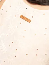 Top de lino color crema, sin mangas, con escote redondo y bordados florales.