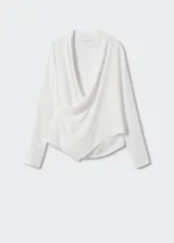 Blusa blanca de escote cruzado drapeado, manga larga y diseño recto.