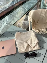 Sweater de tejido de punto con textura de ochos, color blanco, de cuello redondo y mangas cortas.