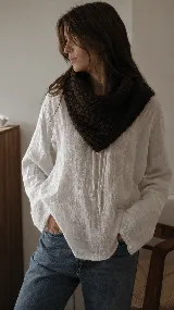Bandana tejida artesanalmente en lana merino, con diseño triangular y textura gruesa. Es una pieza versátil y térmica, ideal para usar como abrigo ligero en el cuello.