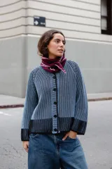 Saco de punto reversible con diseño de rayas verticales en dos colores, cuello a la base, manga larga y cierre frontal con botones negros.
