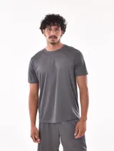 Remera deportiva de manga corta, color gris claro con sutil textura de rayas horizontales. Presenta cuello redondo y costuras reforzadas en los hombros.