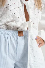 Pantalón pijamero celeste a rayas verticales blancas, de corte palazzo y cintura elástica.