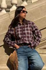 Bomber corta a cuadros en tonos bordó, beige y azul, con cierre frontal y cuello mao de ecocuero color marrón oscuro. Presenta mangas largas con elástico en los puños y en la cintura para un ajuste tipo globo.