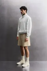 Short jogger marrón de corte relaxed fit, confeccionado en tejido compacto de algodón, con cintura elástica ajustable, bolsillos frontales en la cadera y bolsillo trasero de plastrón.