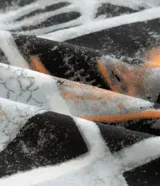 Remera blanca de algodón con cuello redondo y mangas cortas. Presenta un estampado grande en la espalda con un collage de nueve máscaras de los miembros de la banda Slipknot, con texto en la parte inferior.