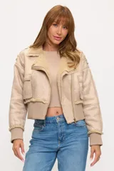 Campera corta tipo aviador en color beige, confeccionada en material con textura gamuzada y forro interno de corderito sintético. Presenta cierre frontal, bolsillos laterales con solapa y puños y ruedo en tejido acanalado.
