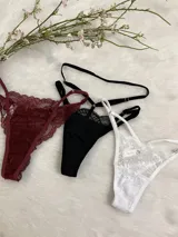 Pack de tres bombachas tipo tanga con diseño de encaje y tiras ajustables. El set incluye modelos en colores bordó, negro y blanco, confeccionados con detalles de encaje floral y terminaciones delicadas.