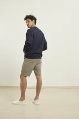 Sweater de punto fino azul con cuello redondo y terminaciones elásticas en canalé.