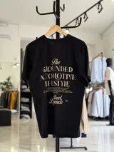 Remera oversize blanca de manga corta, con gran estampado tipográfico en color rojo en la espalda con la leyenda "The Grounded Automotive Lifestyle".