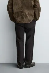 Pantalón de corte recto confeccionado en tejido de sarga con estructura diagonal. Presenta cintura elástica, bolsillos delanteros, bolsillos traseros de vivo y cierre frontal con cremallera y botón.