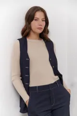 Chaleco azul con cuello en V y cierre frontal con botones marrones.