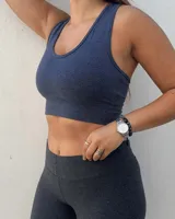 Top deportivo azul jaspeado, sin relleno (push up), con breteles anchos y banda inferior elástica.