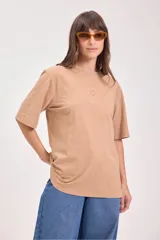 Remera de algodón color camel, corte holgado y manga corta, con un pequeño bordado de un sol en el pecho.