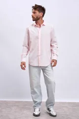 Camisa de manga larga color rosa claro con botones. Corte clásico.