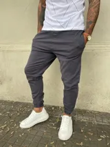 Pantalón babucha gris de gabardina con cintura elástica y puños ajustados.