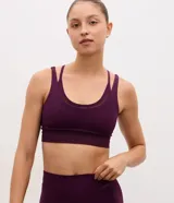 Top deportivo de microfibra color bordó, con escote en U, breteles finos y detalle de superposición de tul.