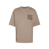 Remera oversize de color marrón claro de la colección Audi Revolut F1 Team de adidas. Presenta mangas cortas amplias, cuello redondo y un estampado frontal en negro con tipografía industrial y el logo de la marca. Incluye una etiqueta roja decorativa en la parte inferior derecha.