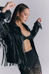 Campera de cuero sintético negro con flecos largos en la espalda y mangas. Presenta un diseño de estrellas pespunteadas en la parte superior de la espalda.