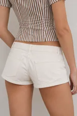 Short blanco de tiro bajo con detalles de cordones cruzados en los laterales y cierre frontal.