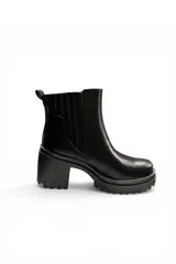 Bota corta tipo chelsea color negro, con elástico lateral estriado, plataforma dentada y taco ancho.